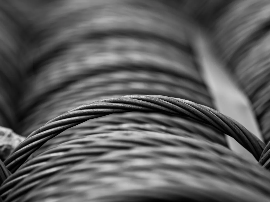 A close-up of coiled steel wire in monochrome