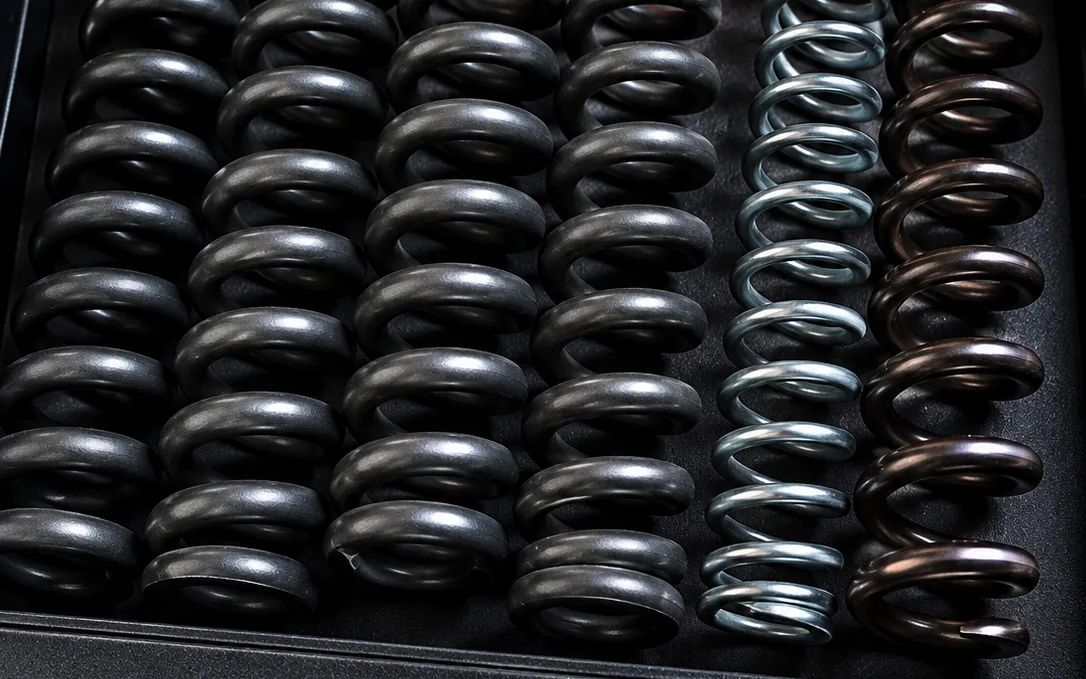 Rows of finished compression springs in a range of sizes and finishes, manufactured by Chetak Spring & Engineers