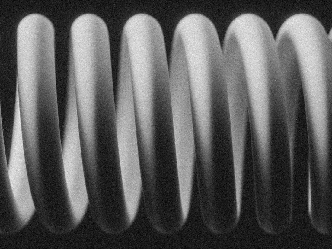 Macro view of the open coils of a helical compression spring