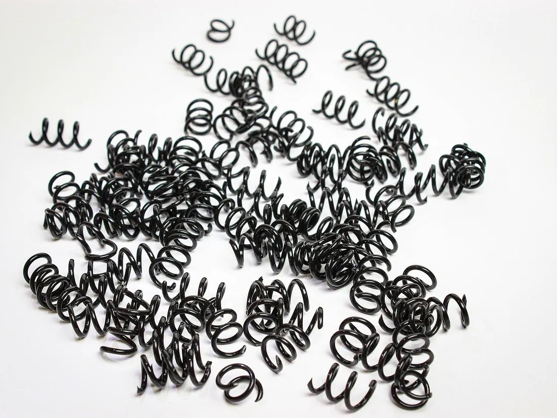 Small tapered conical wire springs on a white background