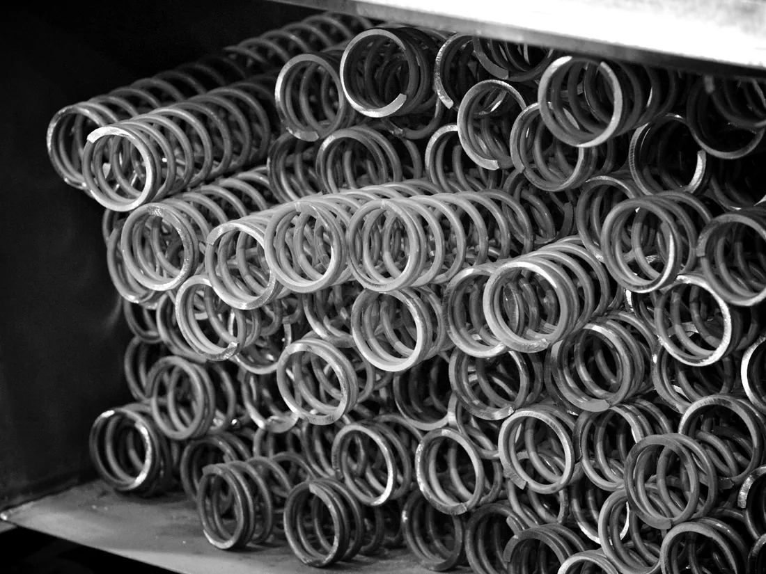Stacked helical compression springs on a workshop shelf