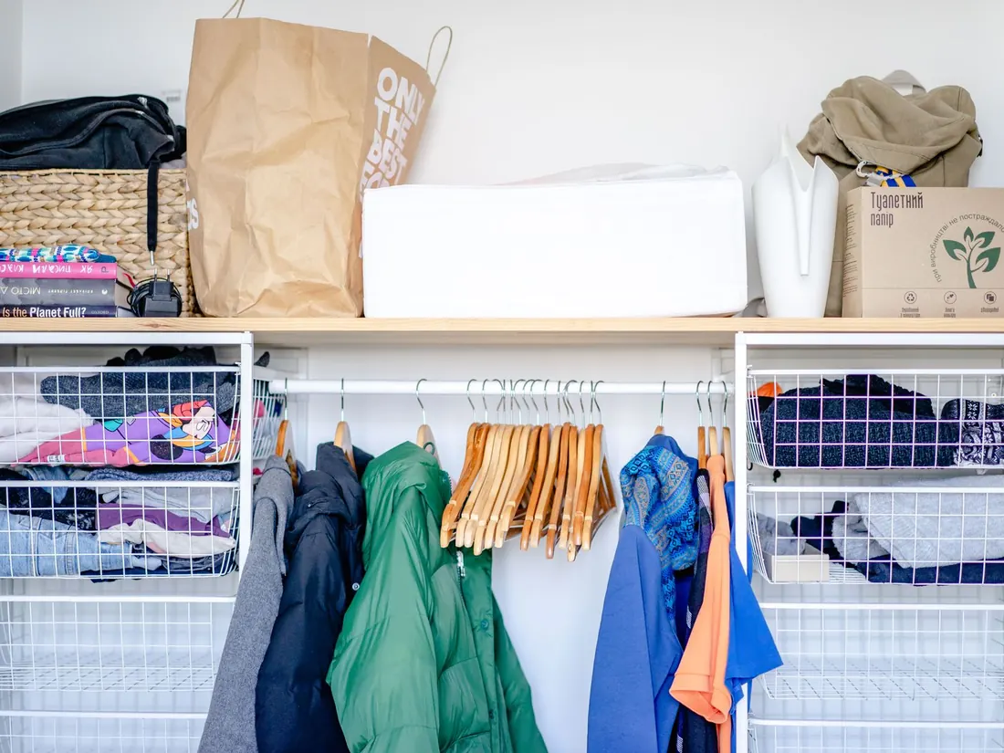 Wire mesh storage baskets built into a wardrobe unit