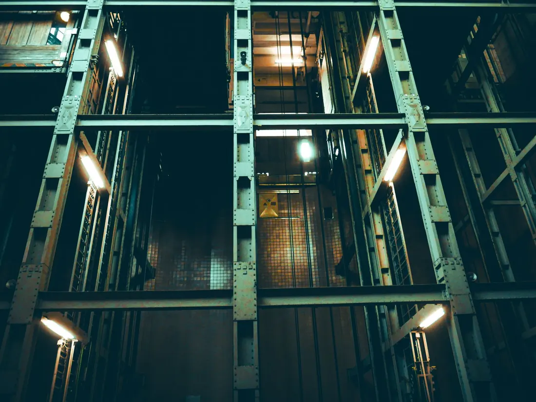 A lift shaft with its steel framework and mesh panels