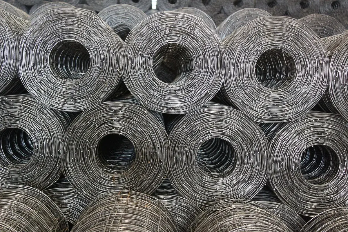 Rolls of galvanised wire mesh stacked in a store