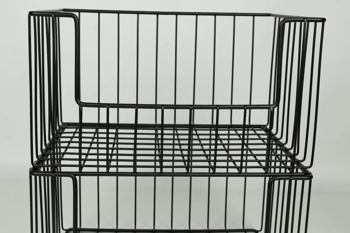 Stacked black steel wire storage baskets ready for dispatch