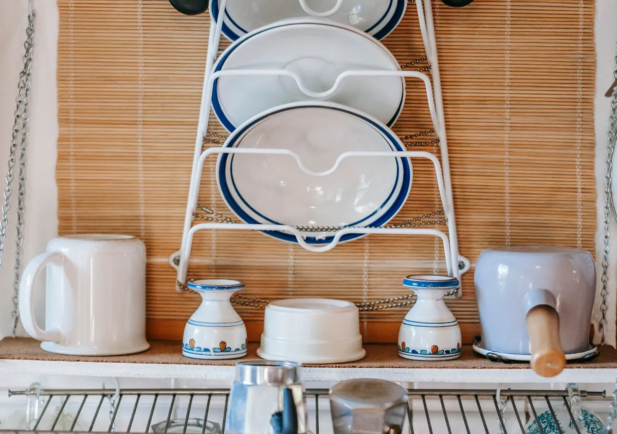 A wire plate rack and wire shelf holding crockery