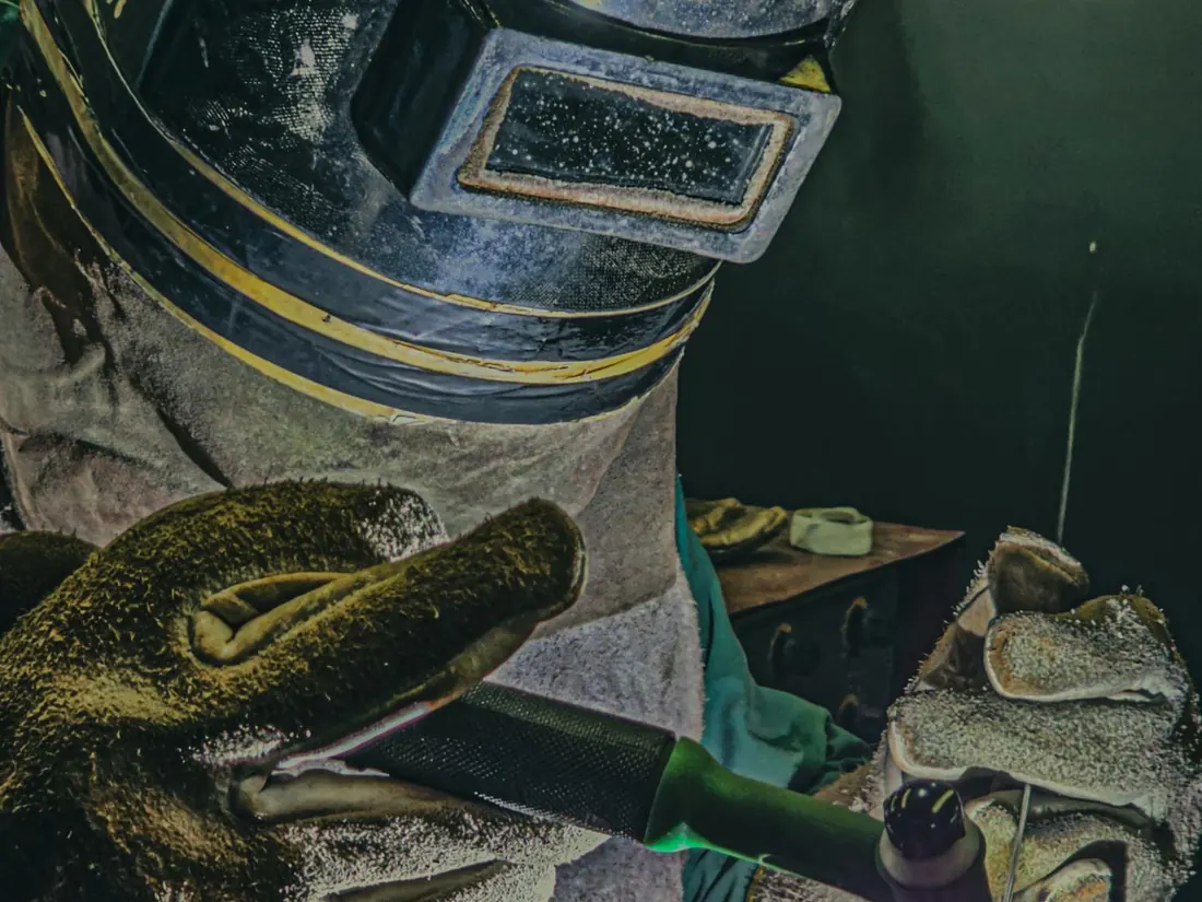 A welder in gloves joining mild steel