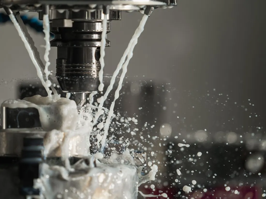 A CNC machine cutting metal with coolant flowing