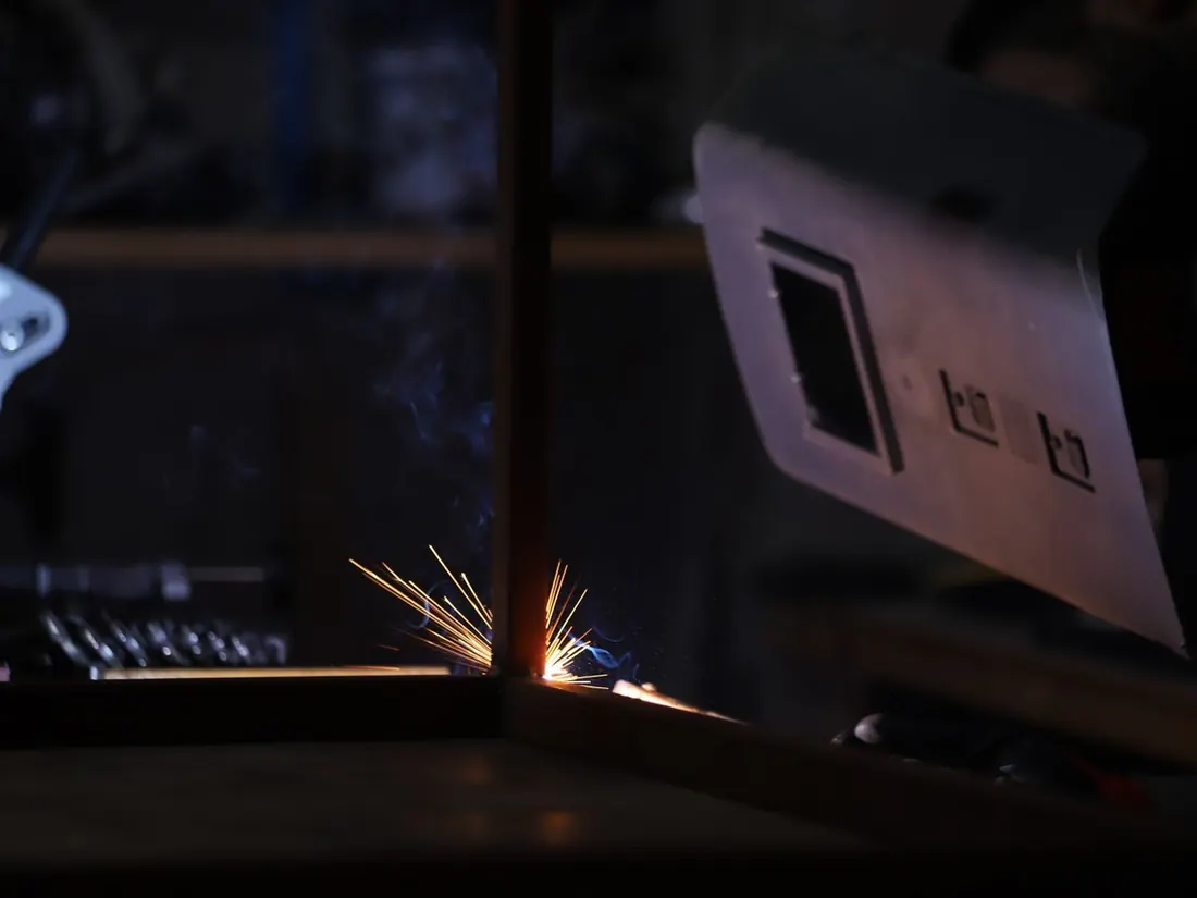 Sparks flying as sheet metal is welded on a jig
