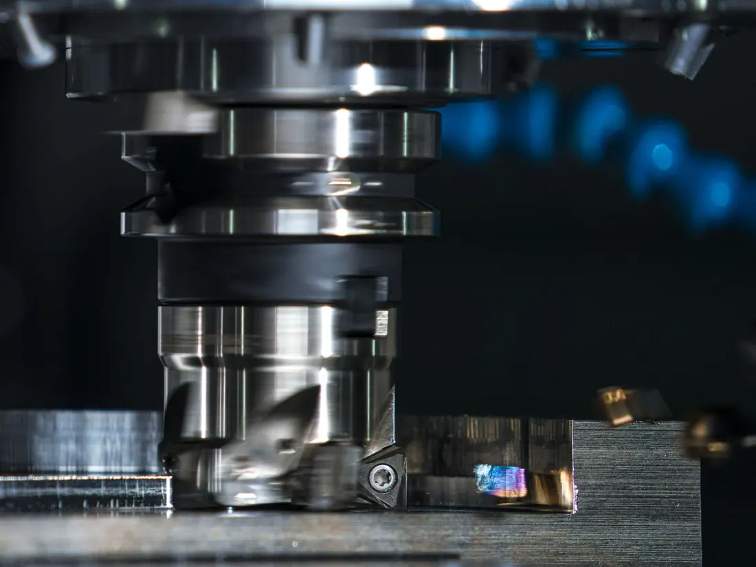 A milling machine cutting a stainless steel piece