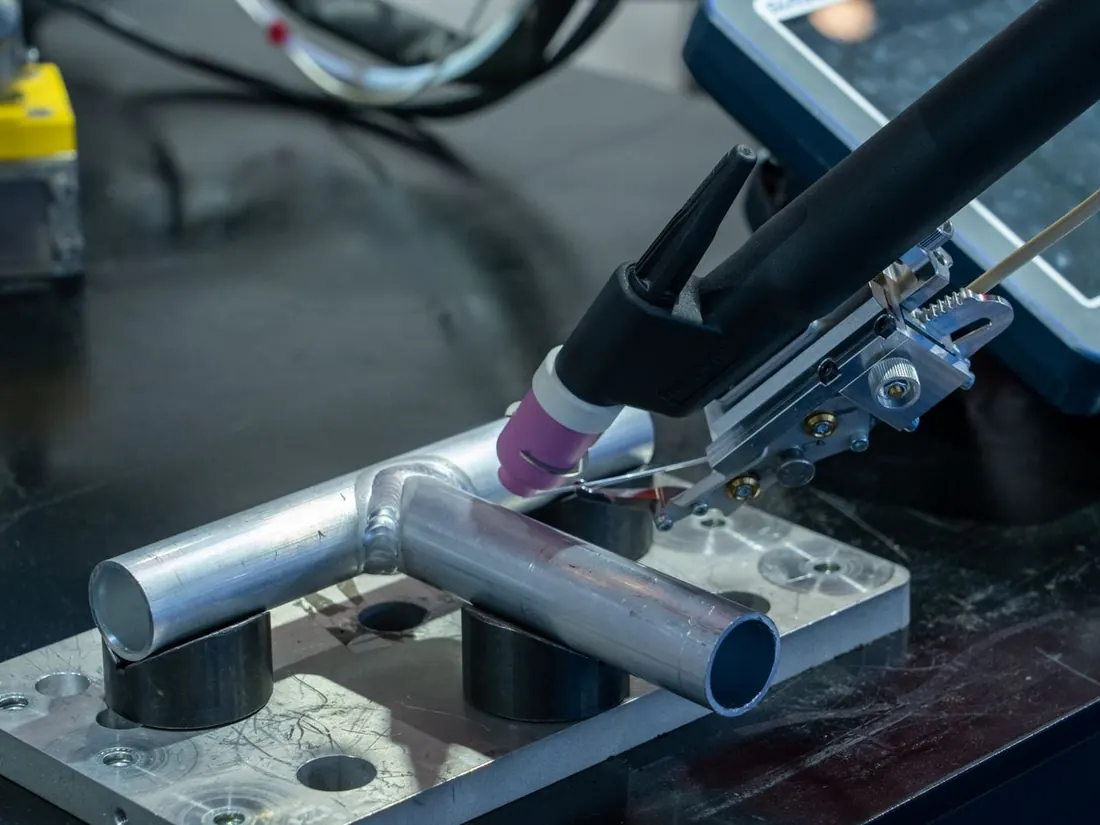 A TIG welding torch joining a steel tube on a jig